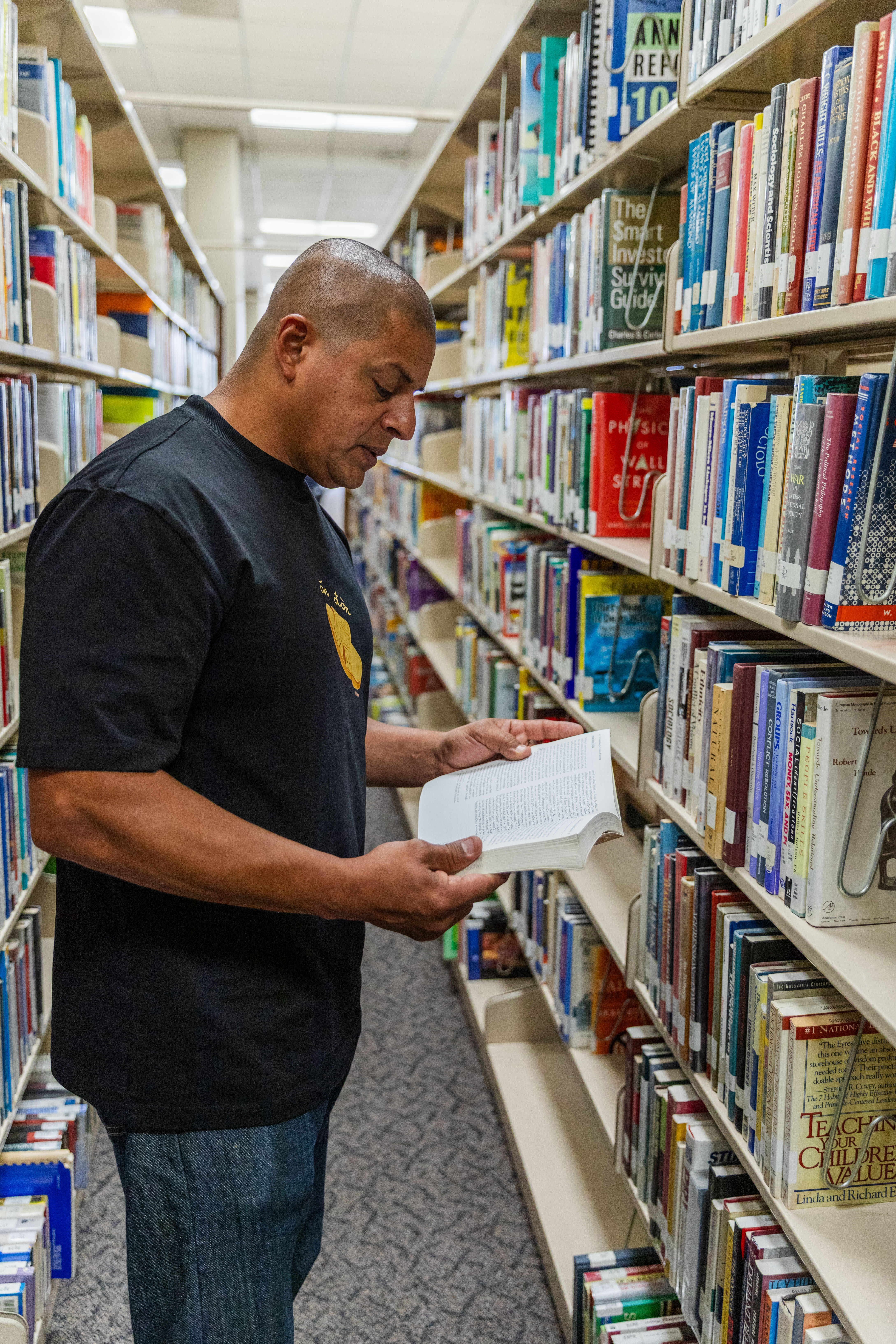 Kevin Reyes standing by a book shelf