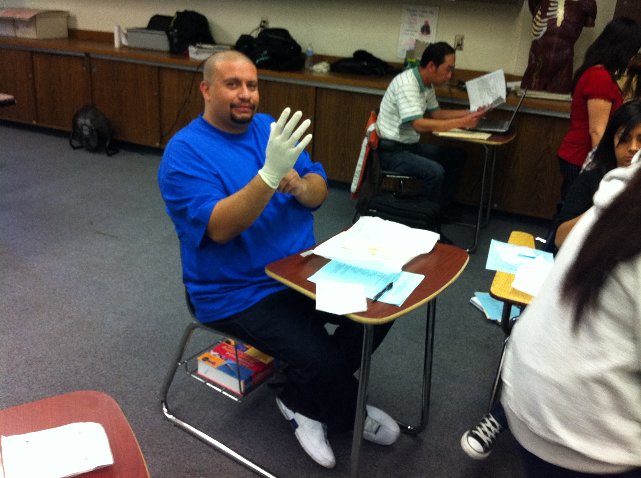 male student putting on latex gloves for class assignment