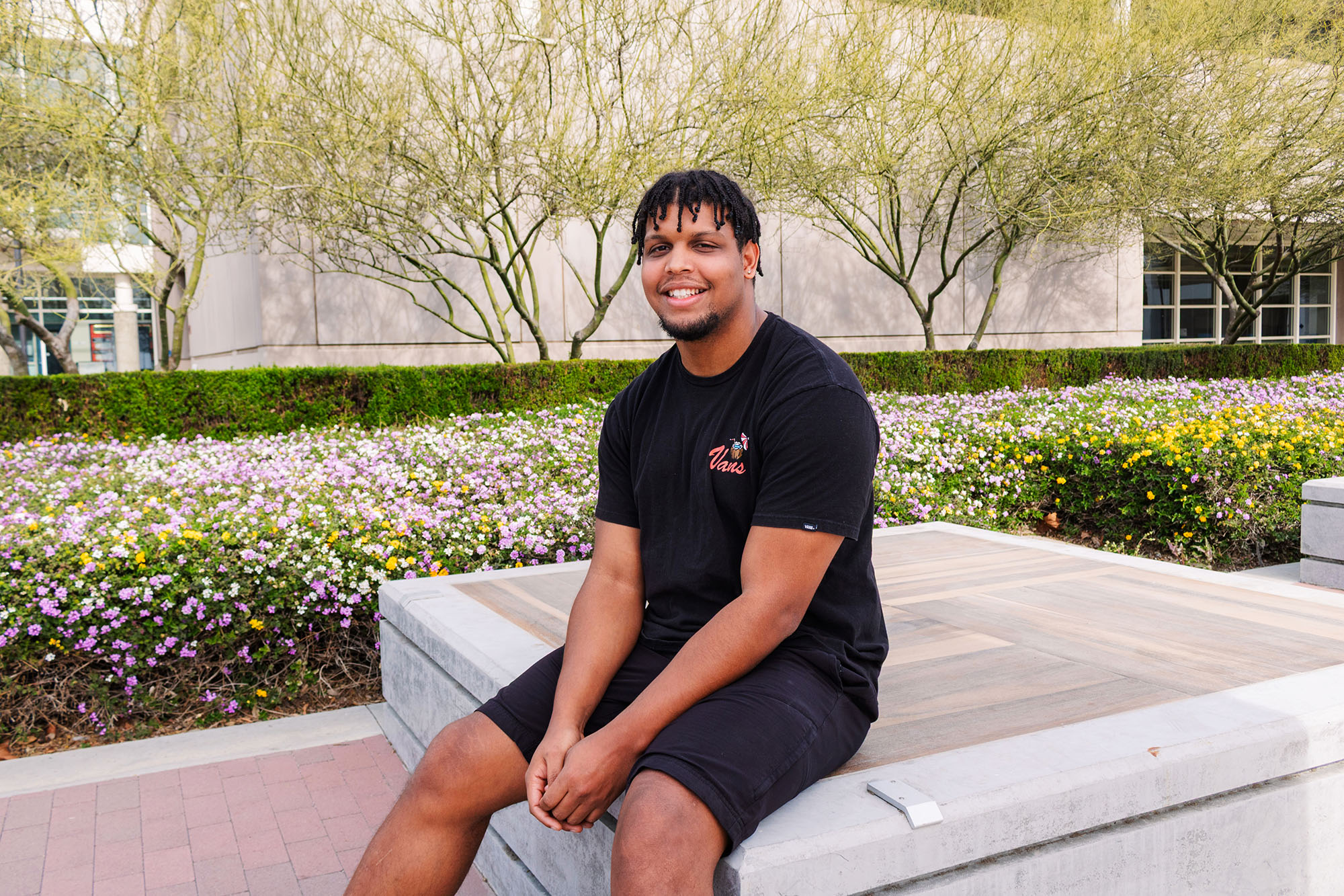 Tyler Fuller sitting on a platform by A Building