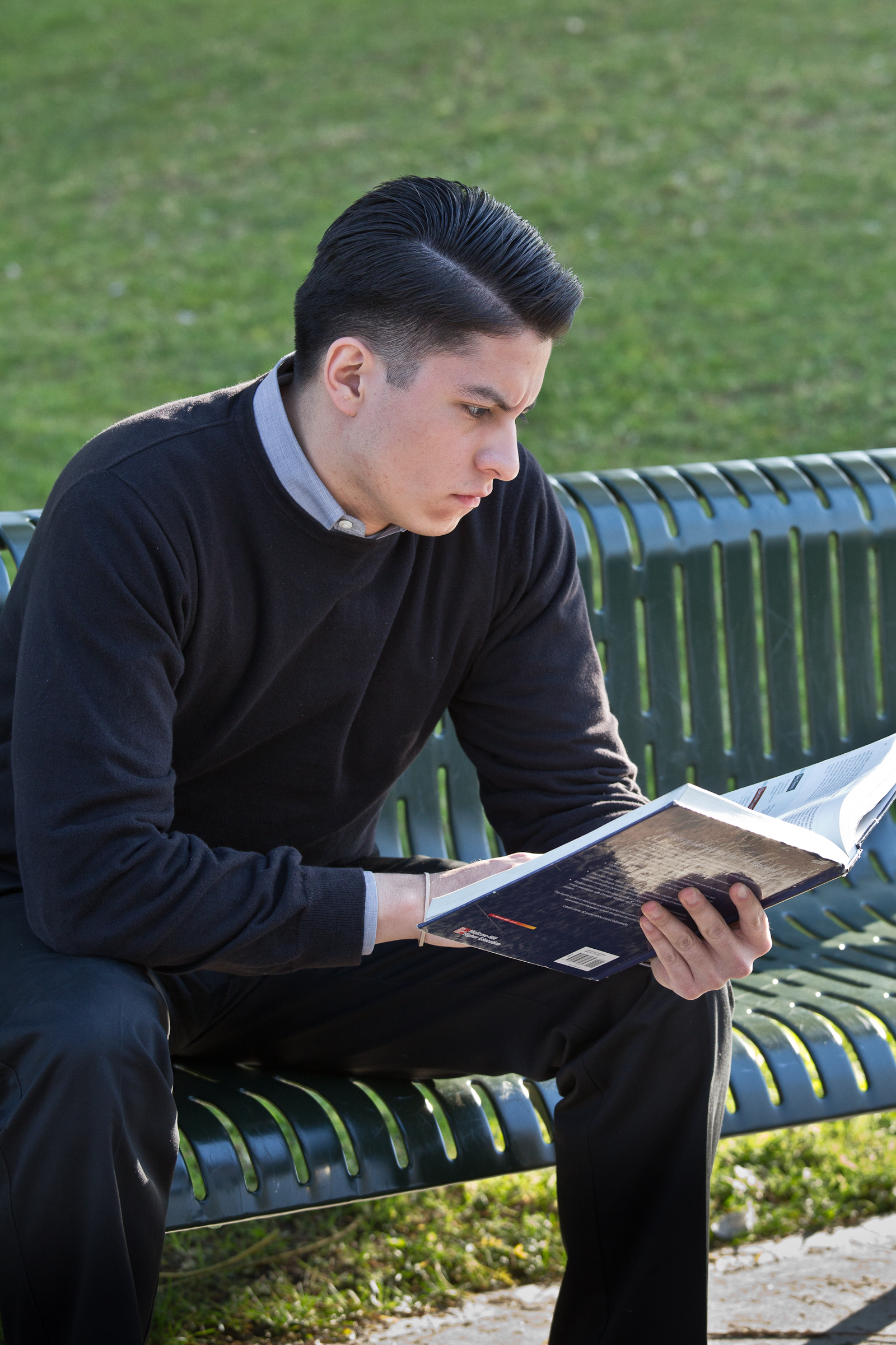 Student Reading while sitting on a bench