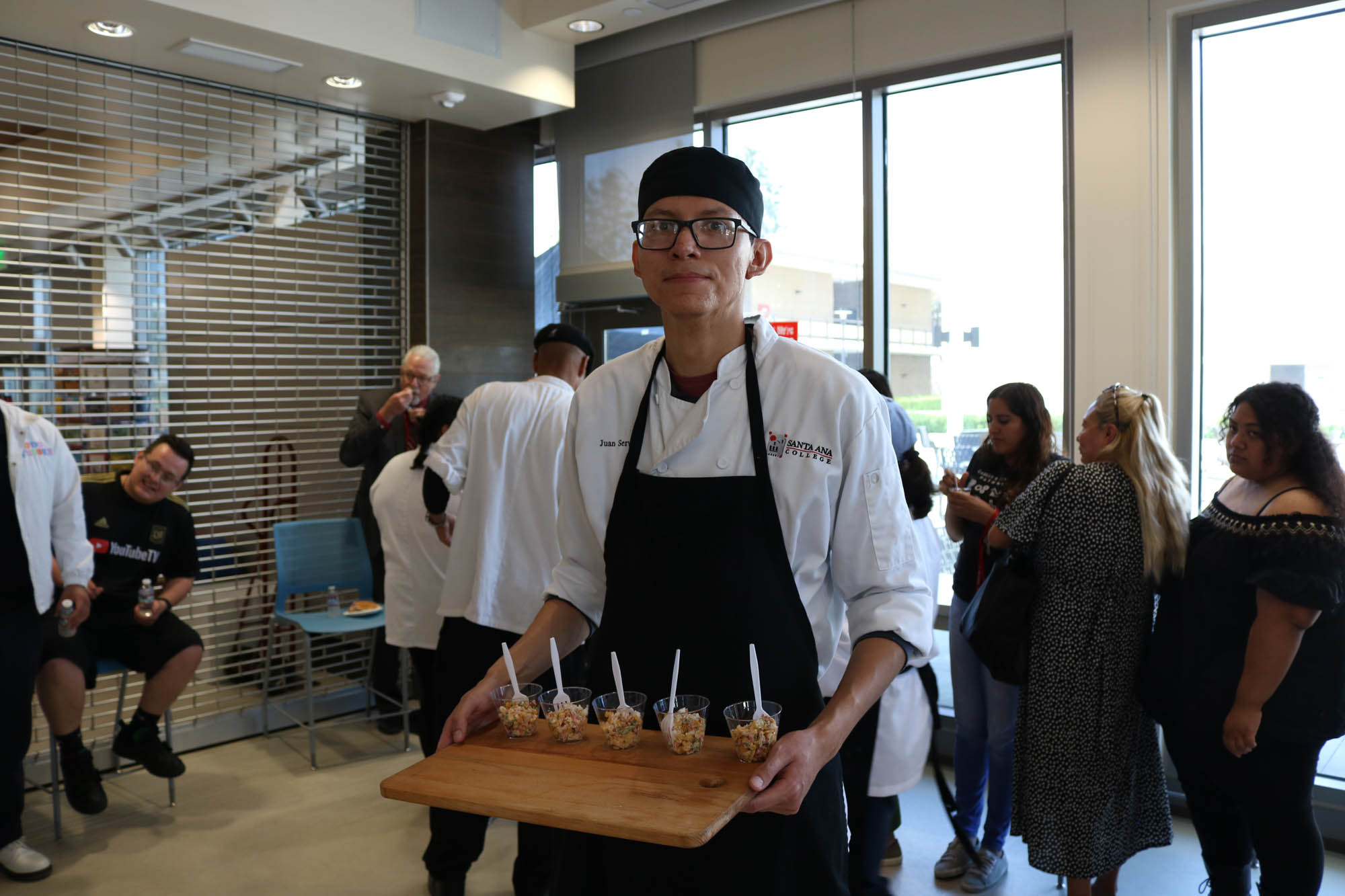 Student holding tray of ceviche salad