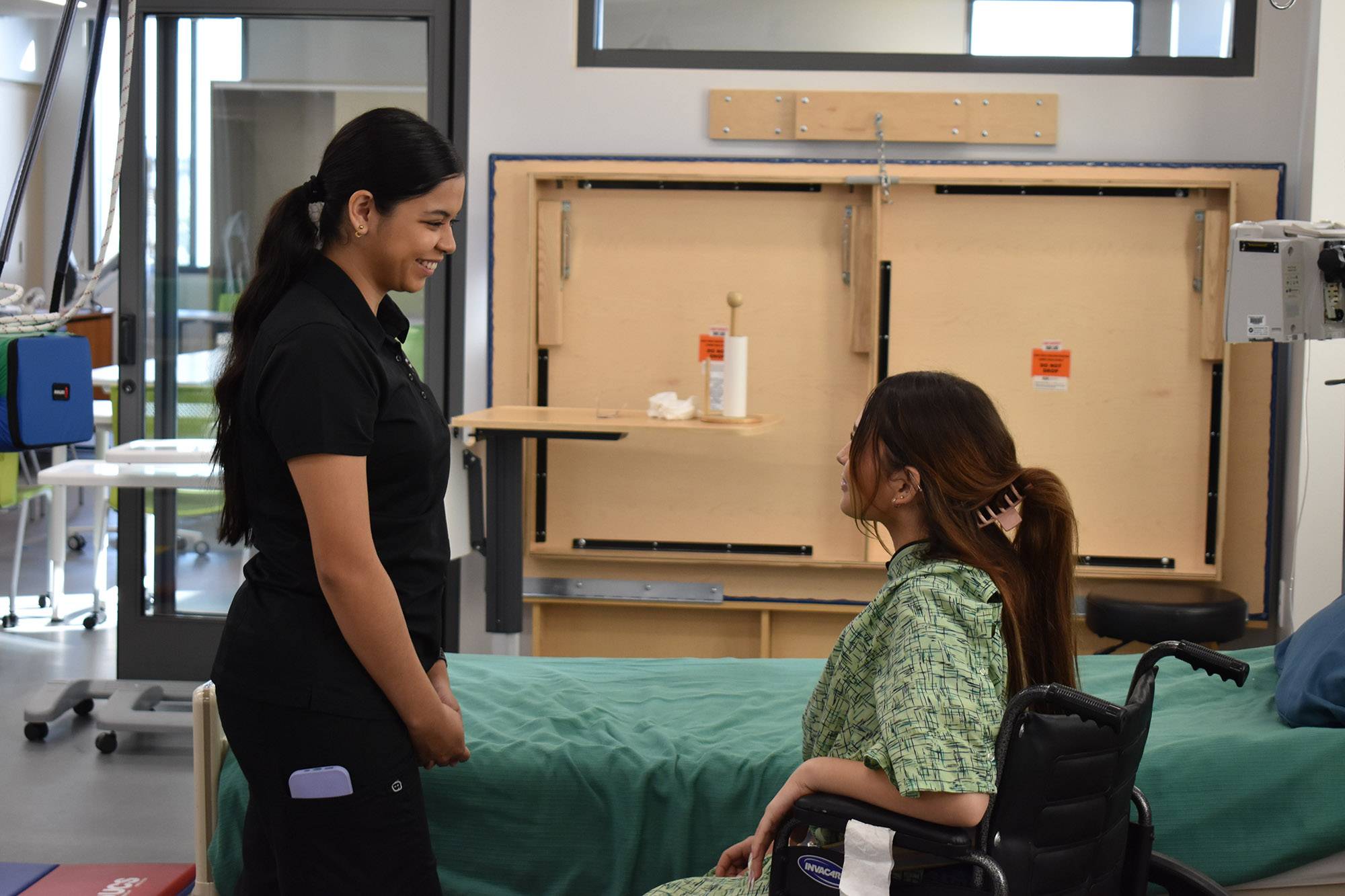 Occupational Studies students learning how to use assistive walking device from instructor