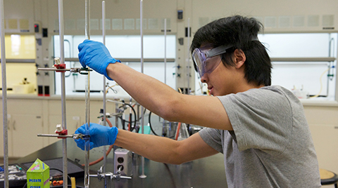 male student using a test tube