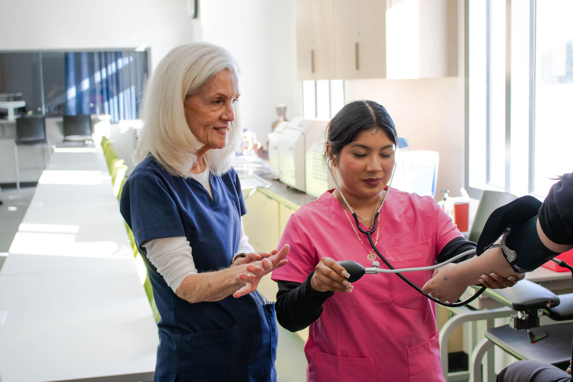 instructor teaching student how to admit patient