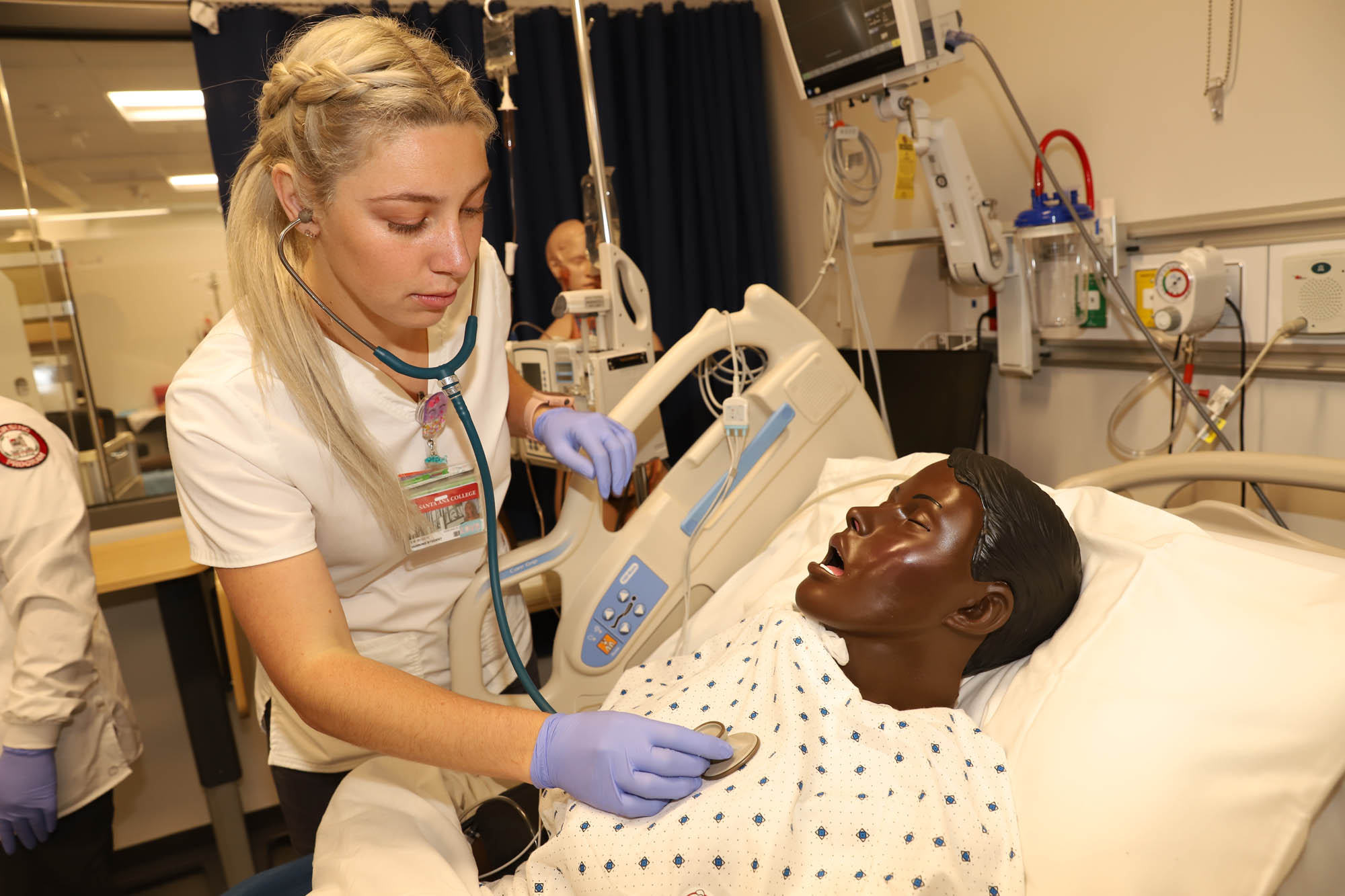 blonde female nursing student practicing on a dummy 