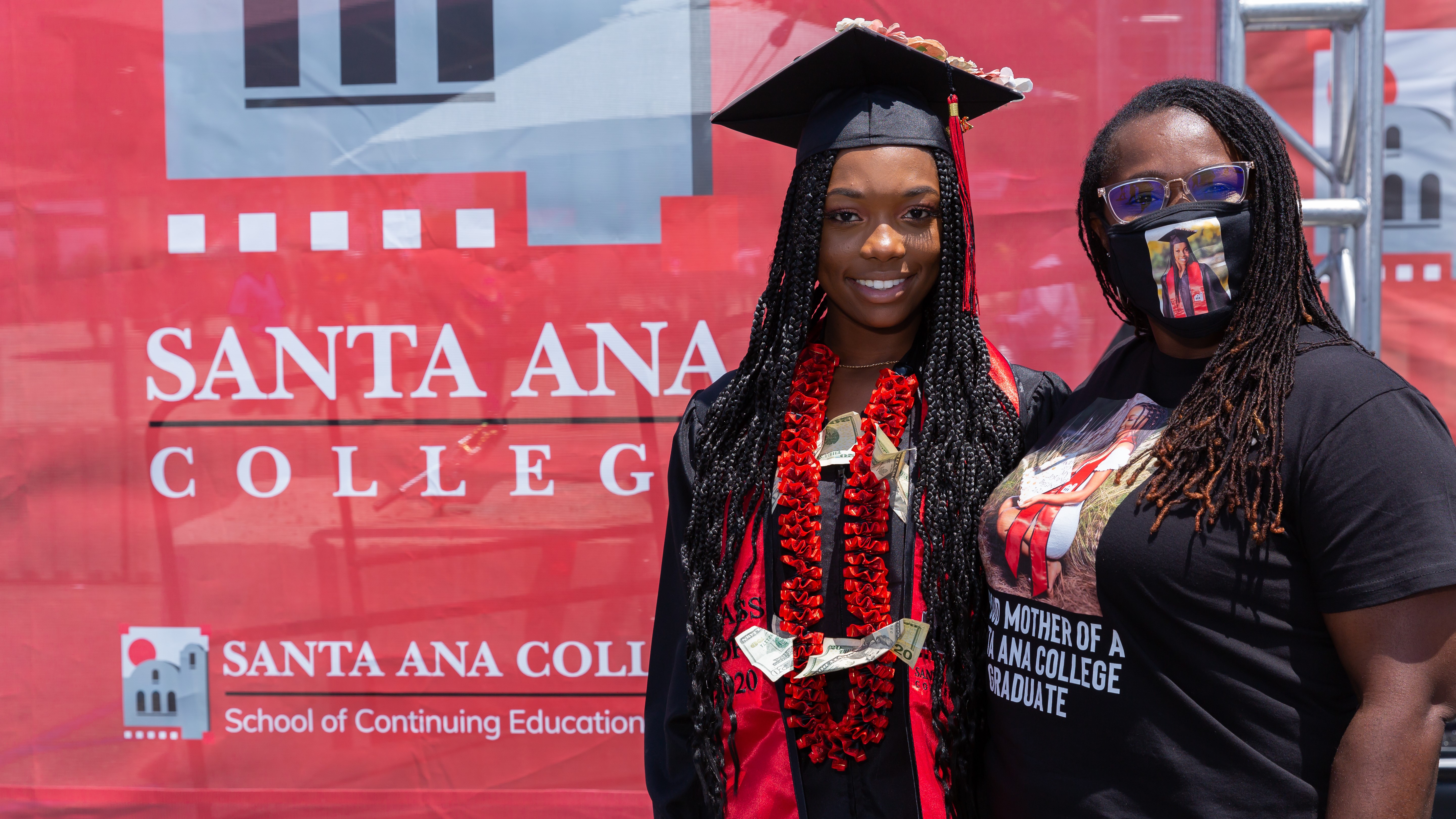 graduating student poses with mother at photobooth at 2021 commencement