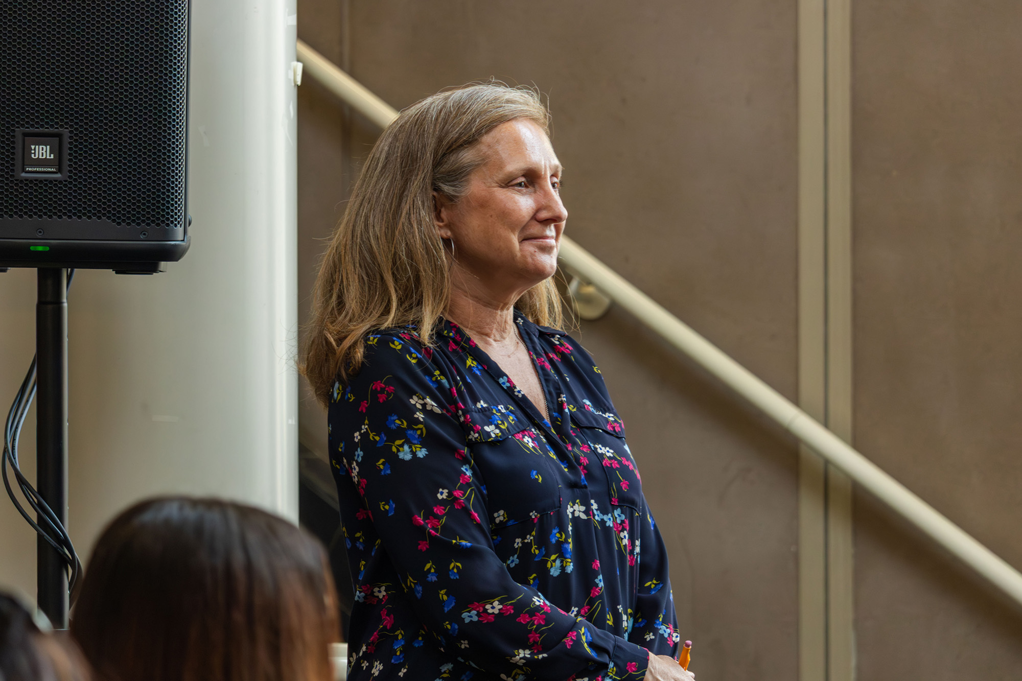 Professor Kim Smith stands up to get recognized at Ribbon-cutting ceremony