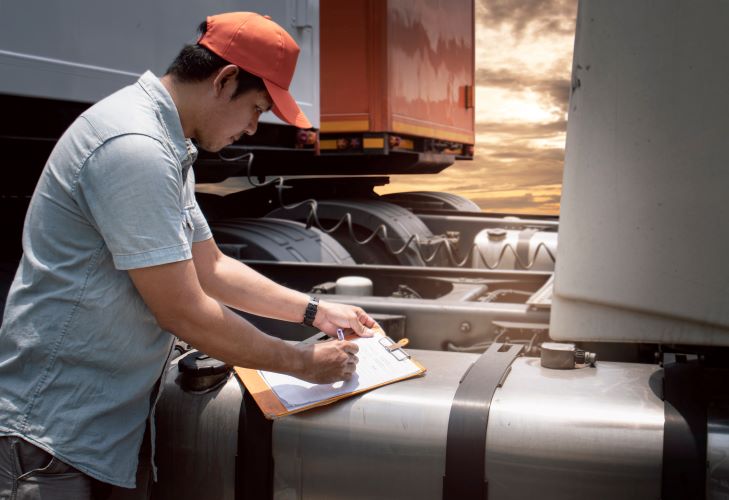 Young asian man inspecting diesel big rig truck with certification from Santa Ana College Continuing Education