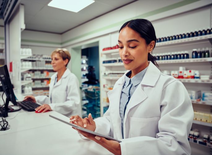 Woman working as pharmacy tech using math skills and prescription labels learned at Santa Ana College