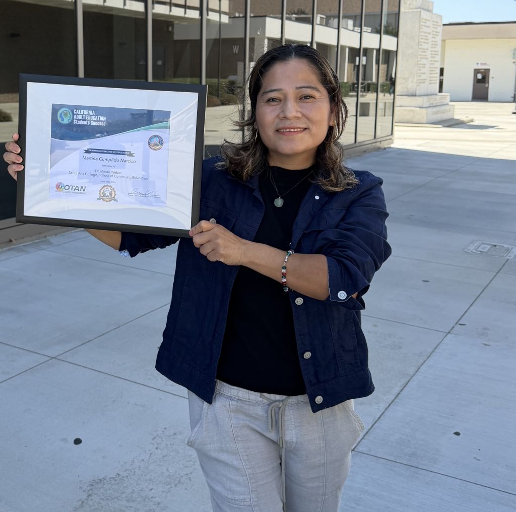 Martina Cumplido Narciso holding her OTAN award at Santa Ana College