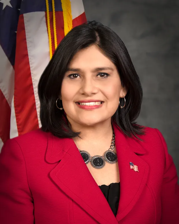 Trustee Cecilia Iglesias standing in front of U.S. Flag