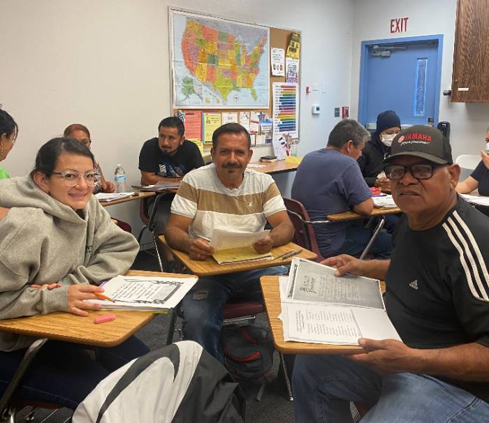 Happy students learning together about great resources that can help them get ready to pass their Citizenship test and become U.S. Citizens.