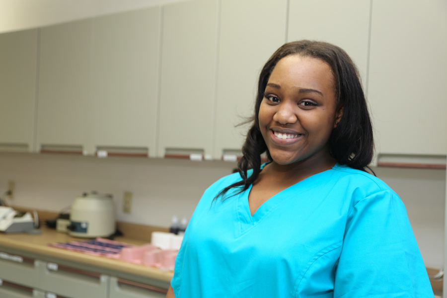 Smiling African American woman working as nursing assistant after completing CNA training at Santa Ana College