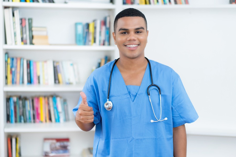 African American man in blue scrubs starting medical career after taking free classes at Santa Ana College